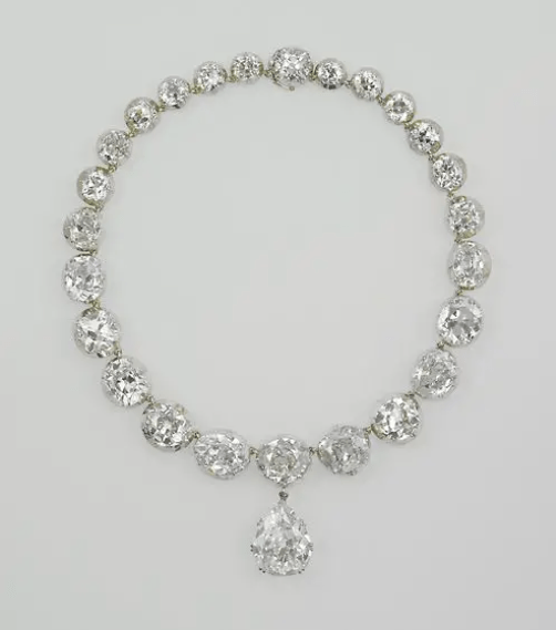 A diamond necklace featuring multiple large, round-cut diamonds and a prominent pear-shaped diamond pendant at the center.
